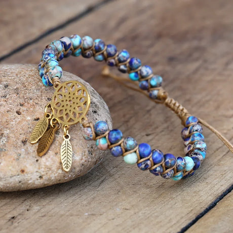 Beaded bracelet with gold charm on a wooden surface