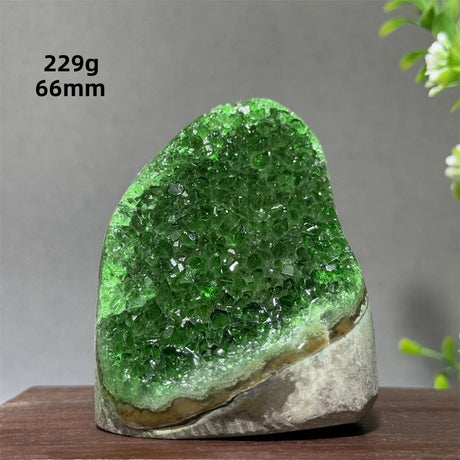 Green crystal rock on a wooden surface with measurements displayed