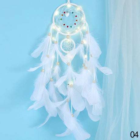 White dreamcatcher with feathers and LED lights on a light blue background