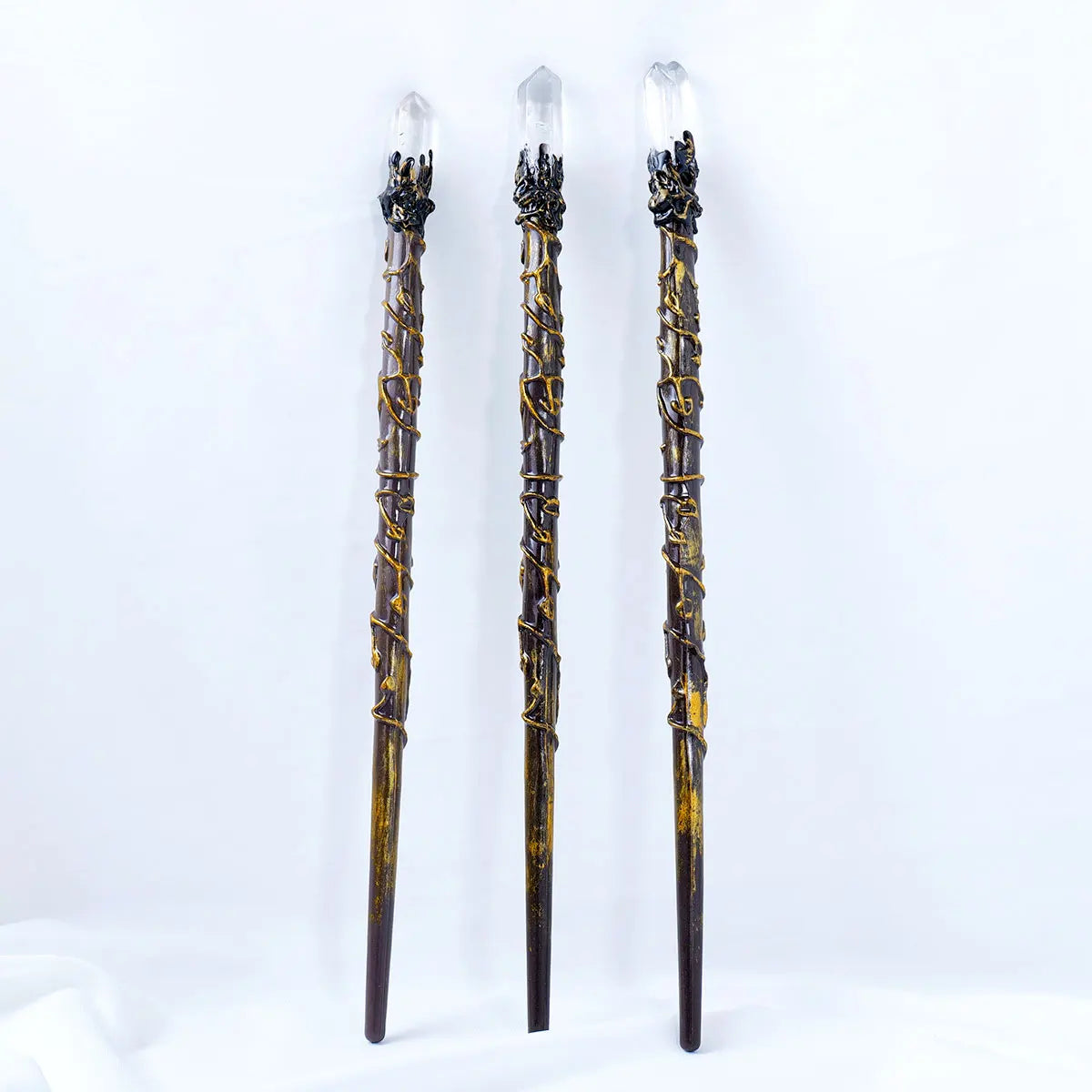 Three decorative sticks with crystal tops on a white background