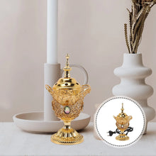 Decorative gold teapot with intricate designs on a neutral background
