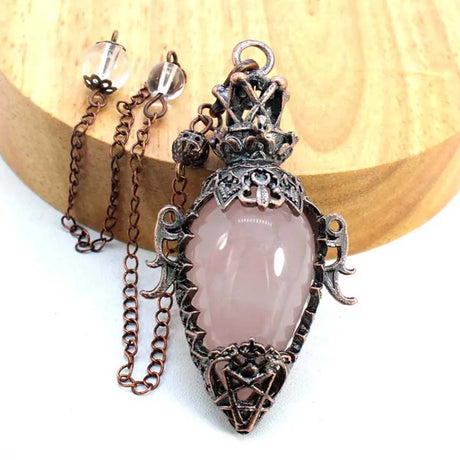 Necklace with a pink stone pendant on a wooden background