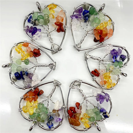 Set of five tree-shaped crystal pendants with multicolored stones on a white background