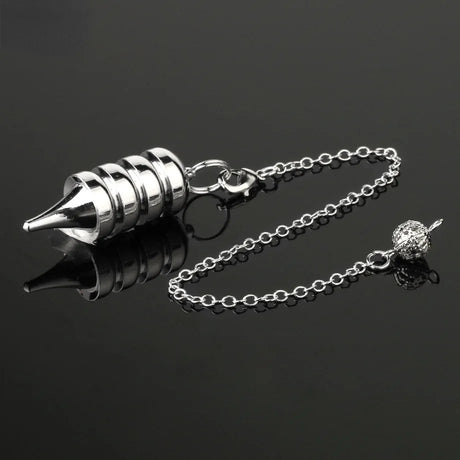 Silver metal pendulum on a chain against a black background