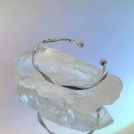 Silver bracelet on a clear crystal rock with a gradient background