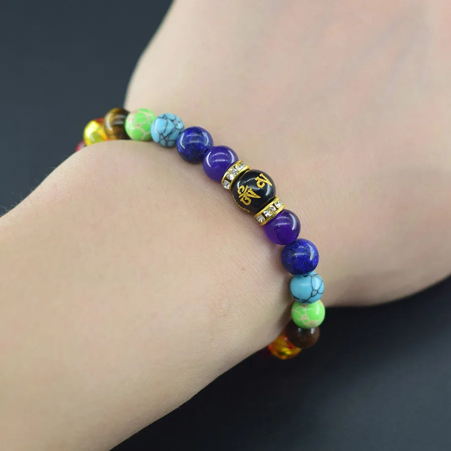 Multicolored beaded bracelet on a wrist against a dark background