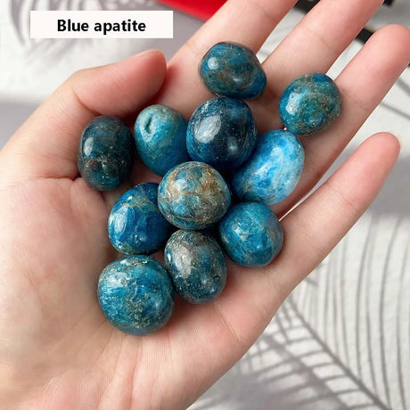 Hand holding blue apatite stones with a blurred background