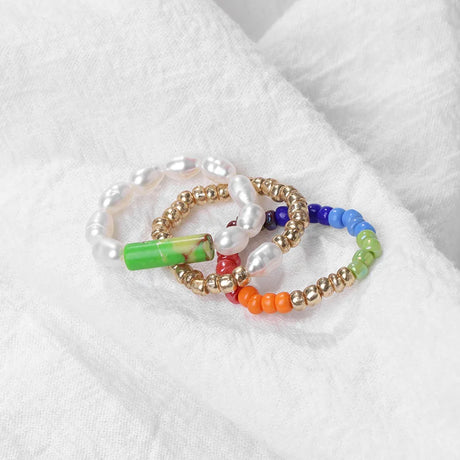 Set of colorful beaded bracelets on a white fabric background
