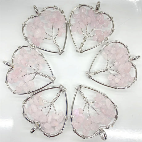 Set of five heart-shaped pink stone pendants with silver wire frames on a white background