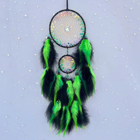 Dreamcatcher with green and black feathers on a light blue background