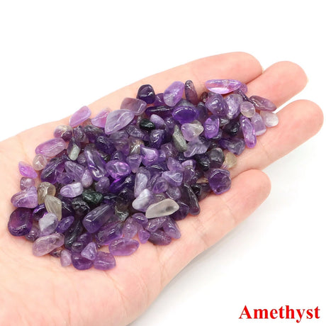 Hand holding a pile of amethyst crystals with 'Amethyst' text on a white background