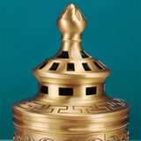 Bronze incense burner with intricate design on a teal background