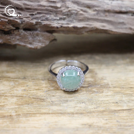 Ring with a green gemstone on a wooden surface