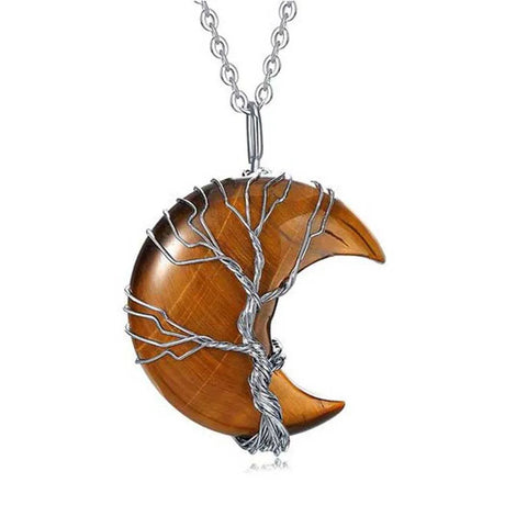 Wooden crescent moon pendant with silver wire wrapping on a white background