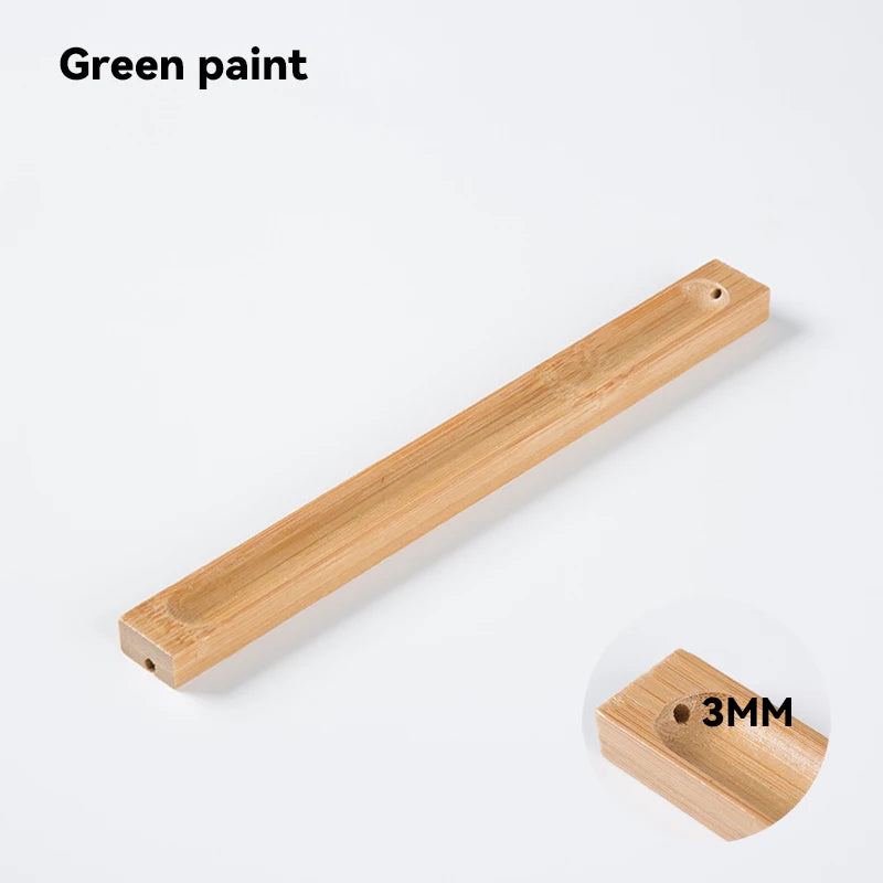 Wooden handle with green paint and a small wooden block labeled '3MM' on a white background.