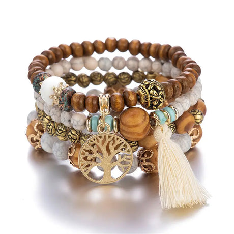 Stack of beaded bracelets with wooden beads, tassel, and tree of life charm on a white background