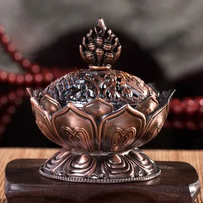 Bronze incense burner with intricate designs on a wooden stand