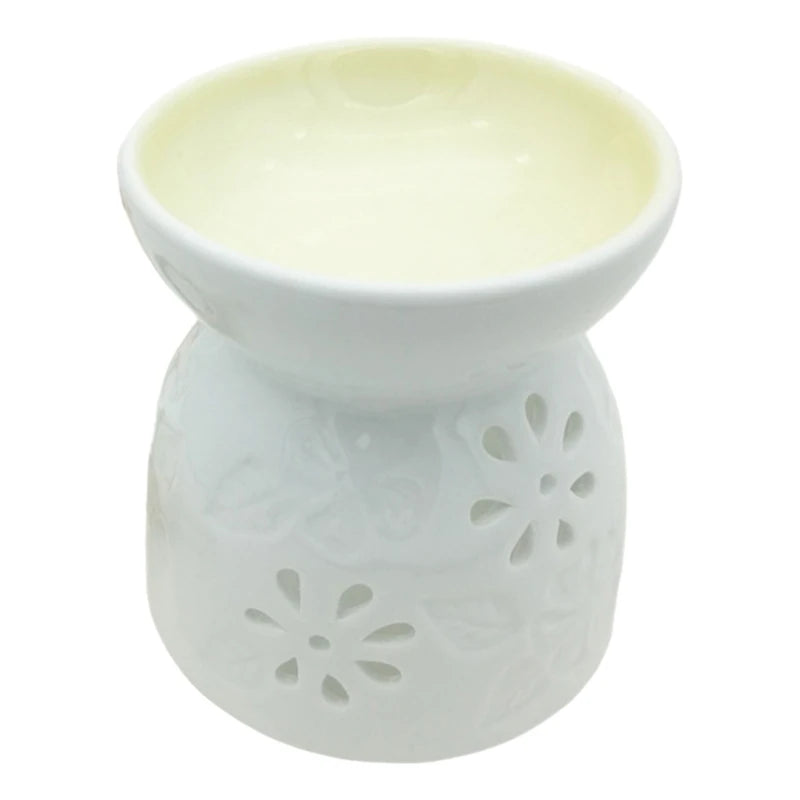 White ceramic oil burner with floral cutouts on a white background