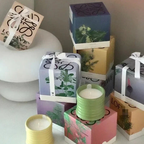 Stack of gift boxes with candles on a white surface