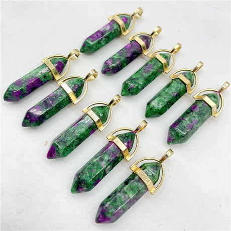 Green and purple crystal pendants with gold accents on a white background