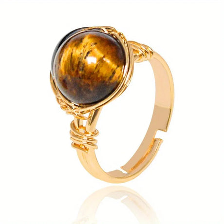 Gold ring with a tiger's eye stone on a white background
