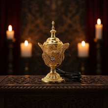 Decorative gold lamp with intricate design on a white background