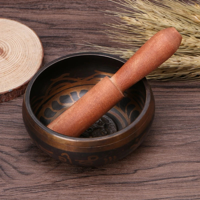 Wooden pestle in a black stone mortar on a wooden surface