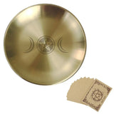 Gold tibetan singing bowl with pentacle and moon designs, accompanied by brown cards with similar designs.