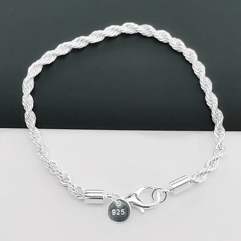 Silver braided bracelet with a charm on a white surface