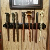 Collection of wooden wands on a holder against a wooden wall.