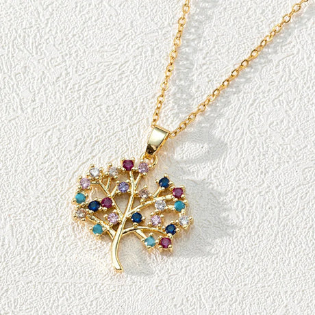 Gold necklace with a tree-shaped pendant featuring colorful gemstones on a light gray background