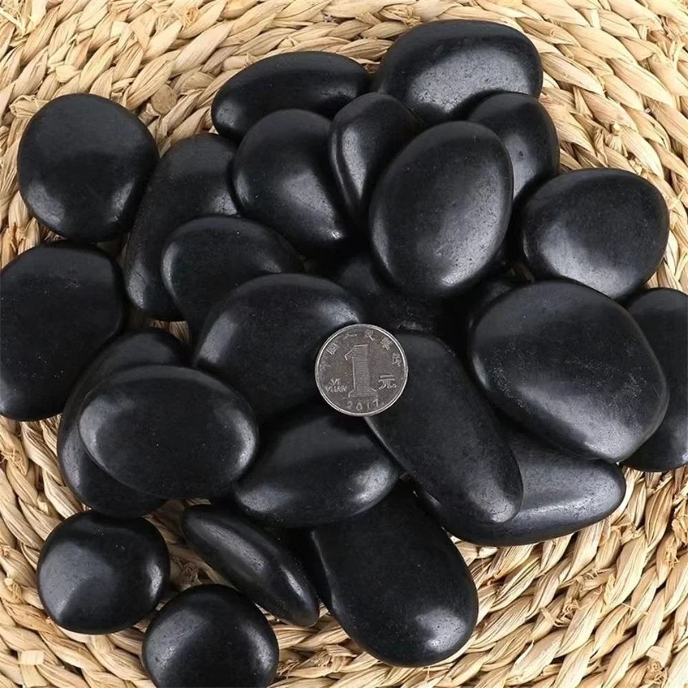 Black stones on a woven mat with a coin for scale