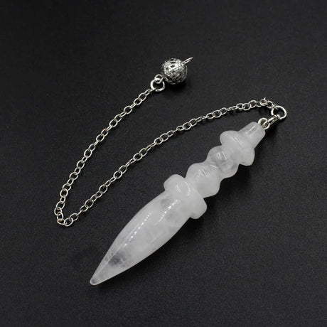 Crystal dagger pendant on a chain against a black background