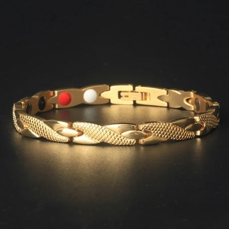 Gold bracelet with red and white beads on a black background