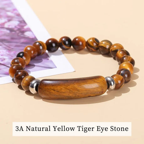 Bracelet with yellow tiger eye stones and wooden accents on a beige background