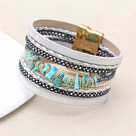 Multistrand bracelet with turquoise stones and gold accents on a white background