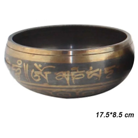 Tibetan singing bowl with gold script on a white background