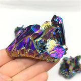 Multicolored crystal held in a hand against a white background