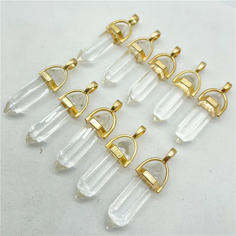 Clear crystal pendants with gold accents on a light gray background