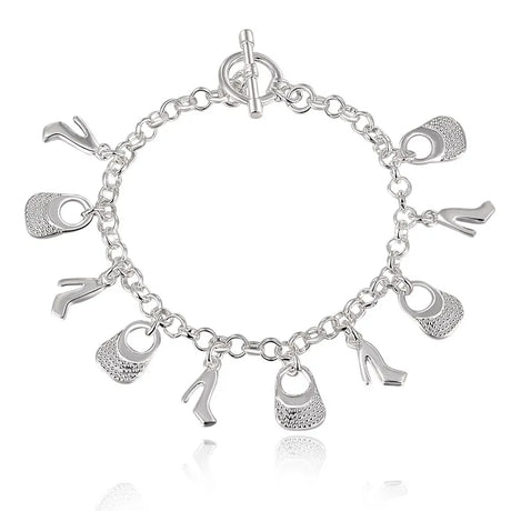 Silver charm bracelet with various charms on a white background