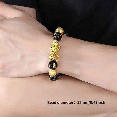 Gold and black beaded bracelet on a wrist with bead diameter text overlay