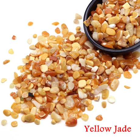 Yellow jade stones with a small bowl filled with stones on a white background