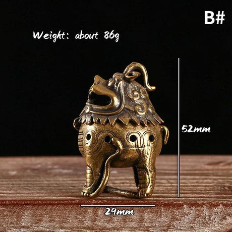 Bronze elephant-shaped object with measurements and weight on a wooden surface