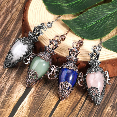 Five decorative pendants on a wooden surface with a leaf in the background