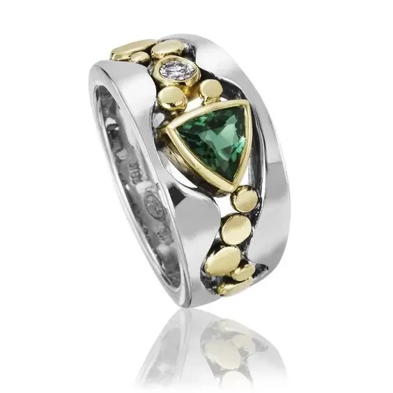 Silver ring with green gemstone and gold accents on a white background