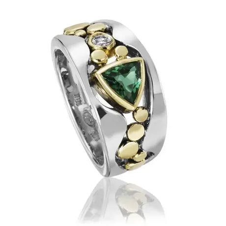 Silver ring with green gemstone and gold accents on a white background