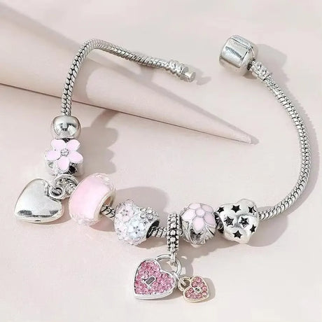 Silver bracelet with heart-shaped charms on a light pink background