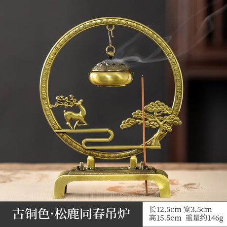 Decorative incense burner with gold finish and intricate design on a dark background