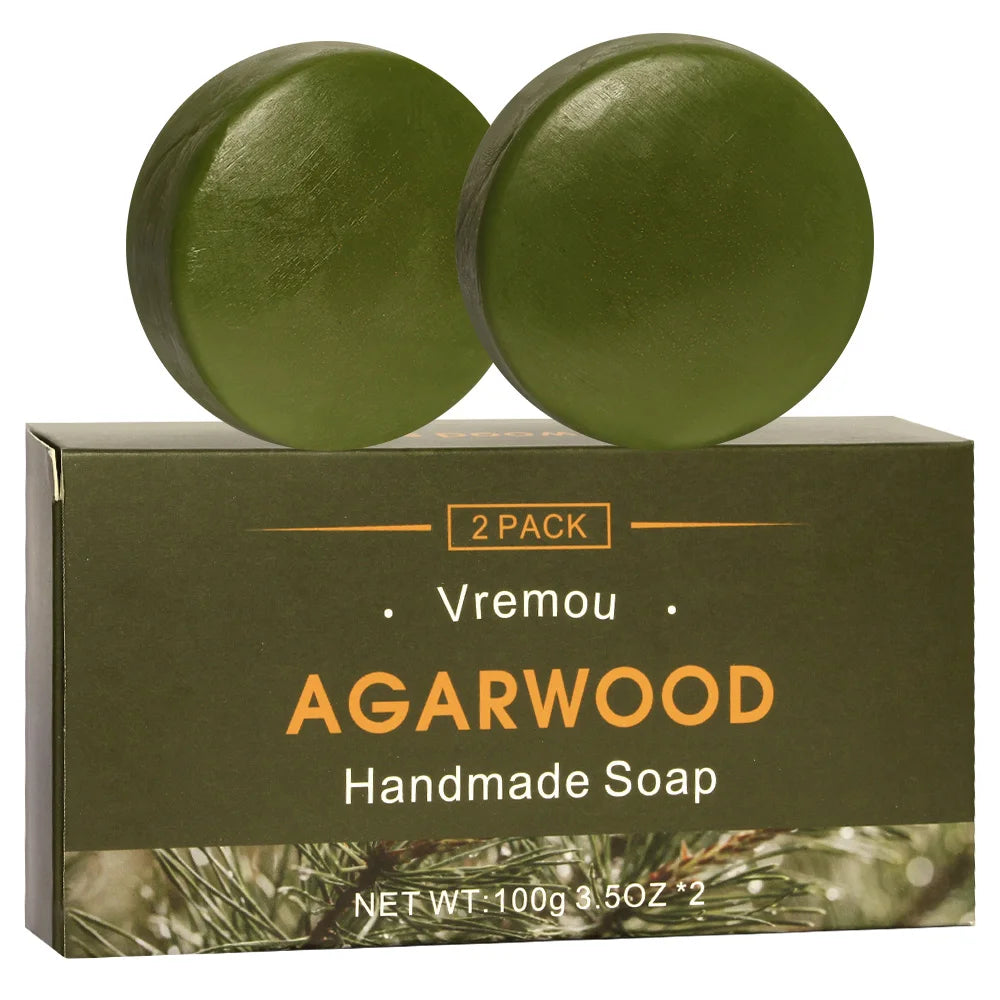 Two green agarwood handmade soap bars on a Vremou branded box with a white background.