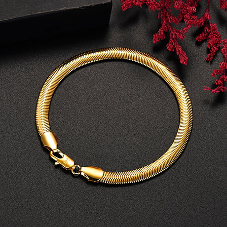 Gold bracelet on a dark surface with red leaves